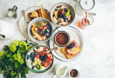 Vegan breakfast with waffles and fruit on a marble table.