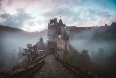 A haunted castle sits on top of a hill in the fog, making it one of the most haunted places in the world.