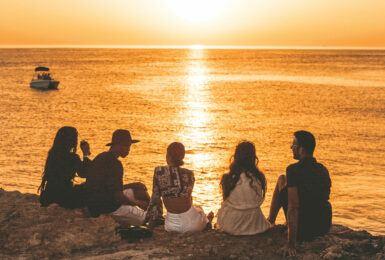 A group of people watching the sunset on a cliff, perfect for capturing the best travel movies.