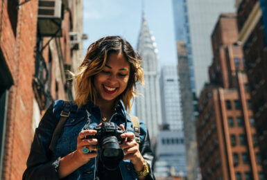 things to do in New York - image of girl looking at camera with empire state building in the background