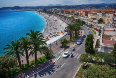 An aerial view of the beach in Nice, France showcasing nearby restaurants.