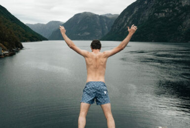 A man jumping off a cliff into a body of water during a trip to Scandinavia.