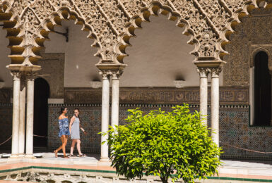 Two women walking in front of an ornate building used as a filming location for Game of Thrones.