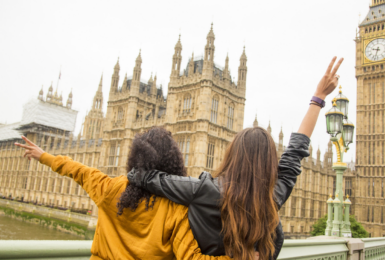 Two young women standing on a bridge overlooking Big Ben in Great Britain.