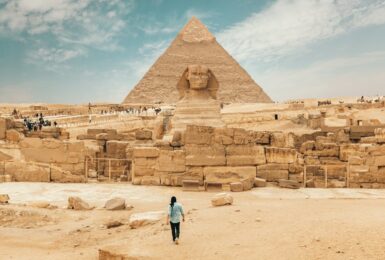 Person walking toward the Pyramids of Giza, Egypt