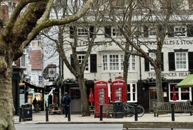 A ted lasso filming location in London featuring trees and a telephone booth.