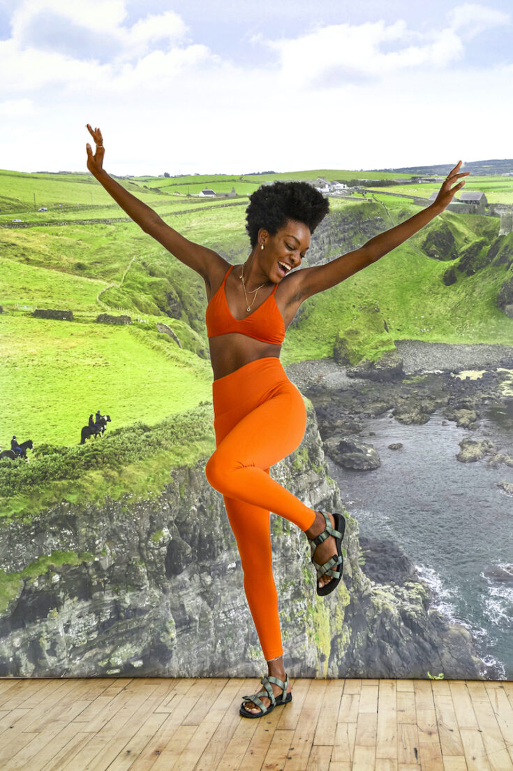Young woman with coast and fields in Northern Ireland as the background.