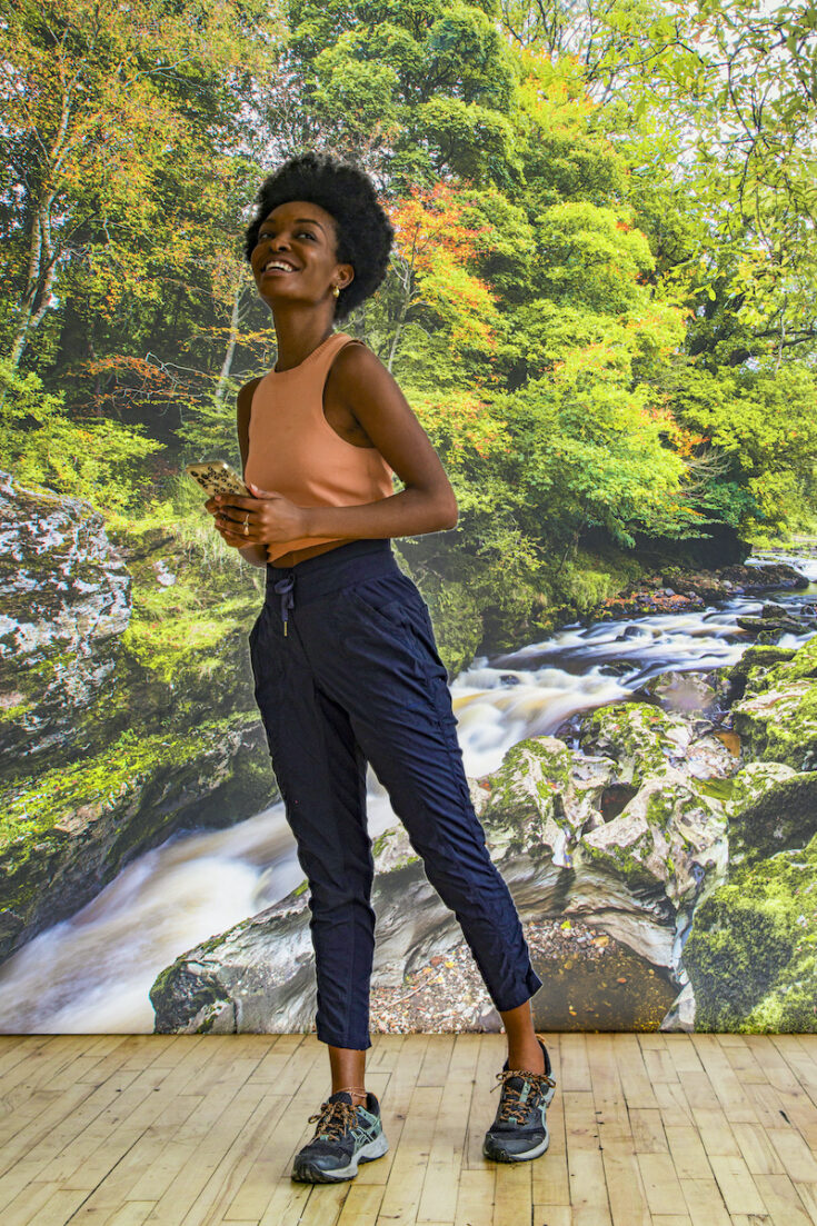 Young woman with a forest and stream in Northern Ireland as the background.