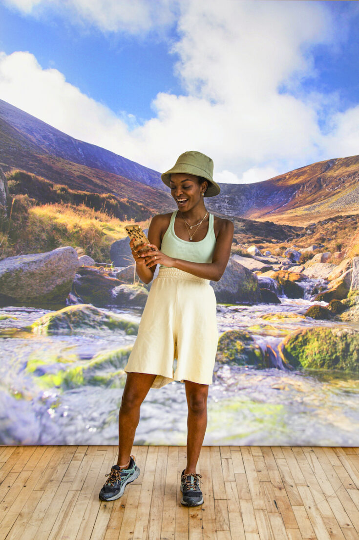 Young woman with stream and hills in Northern Ireland as the background.