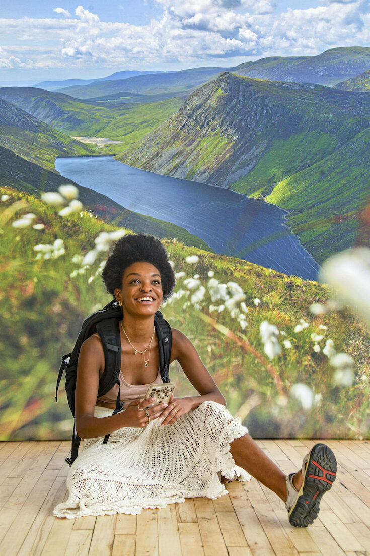 Young woman with a river and mountains in Northern Ireland as the background.