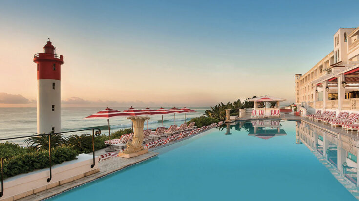 View of The Oyster Box Hotel pool and lighthouse in Durban, South Africa.