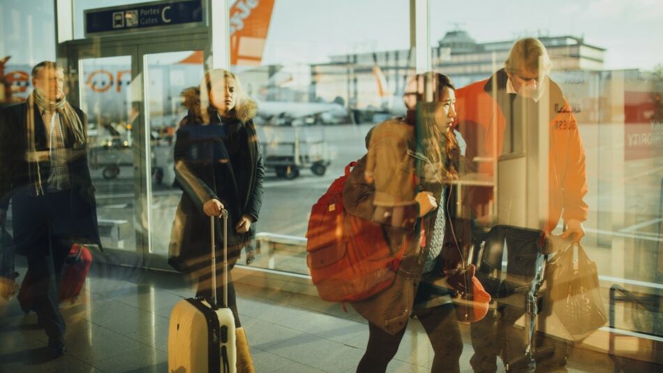 A group of people navigate the airport by themselves, walking through various terminals.