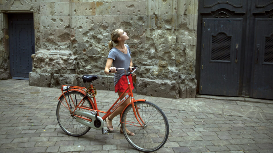 self improvement - image of a girl pushing a bike through a street in Barcelona