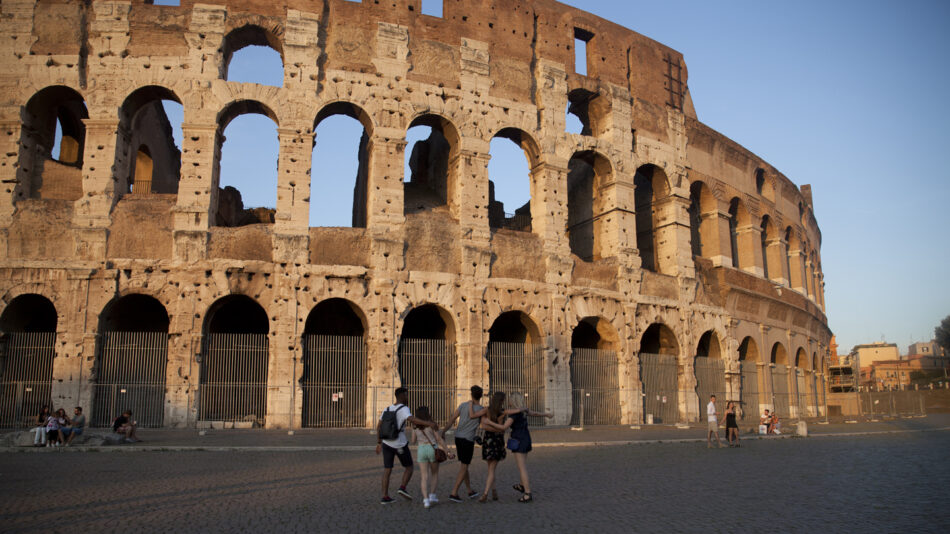 A group of people on a trip to Europe, standing in front of the colossion.