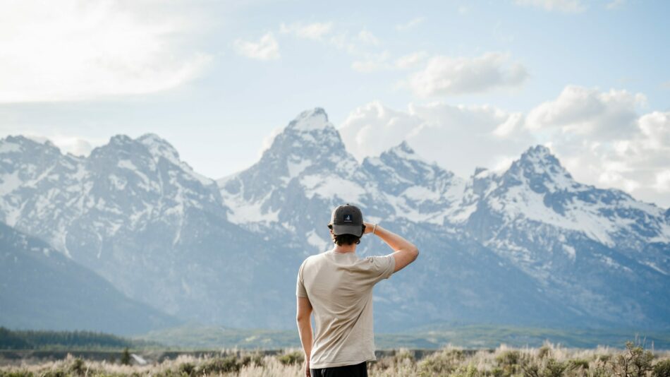 man looking over at mountain range, solo travelling