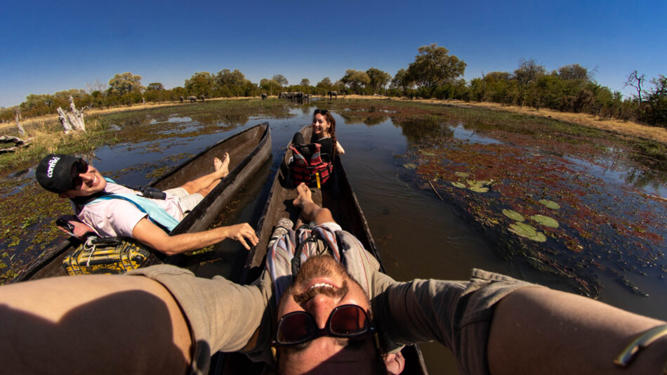 Two people taking a selfie in a canoe on the Okavango Delta, Botswana.