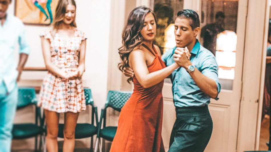 A man and woman dancing tango in a restaurant.