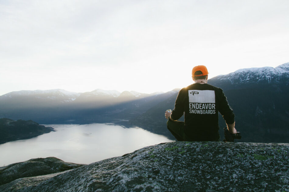 man sitting on rock overlooking lake in Canada