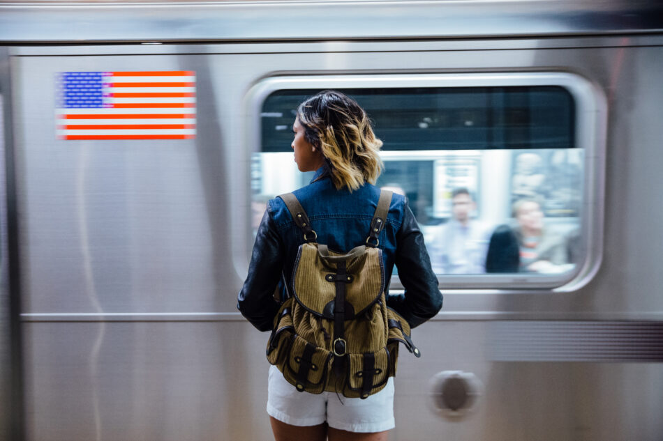 Woman waiting on platform as a train speeds past