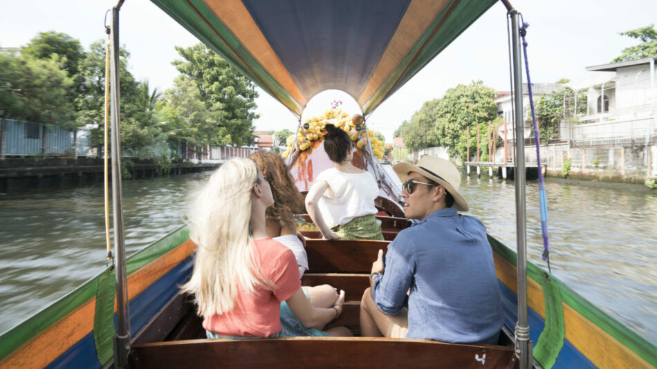 A group of people traveling down a canal in Asia.