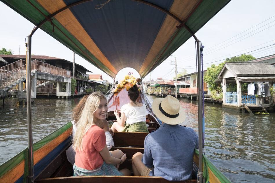 Tourists on a small boat in a narrow asian waterway