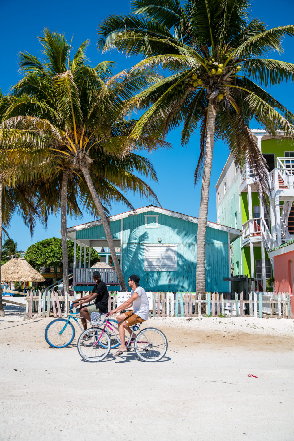 Cycling past wooden buildings and coconut trees