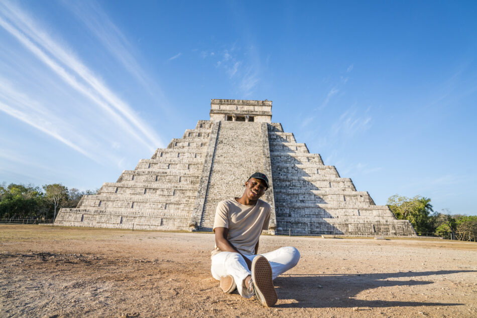 Young man smiling in front of a Mayan monument