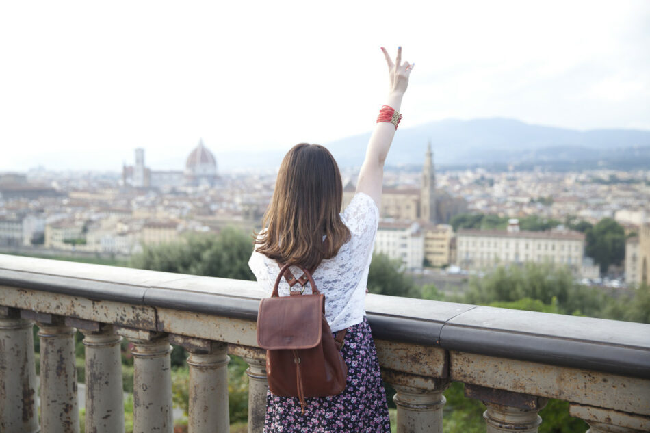 Girl doing peace sign over florence, italy