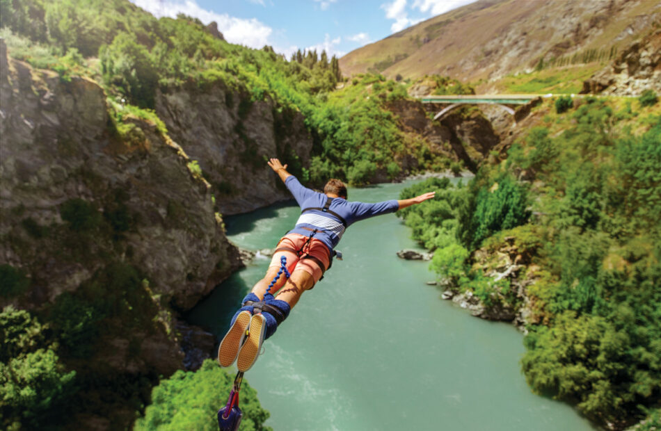 A person zip lining over a river.