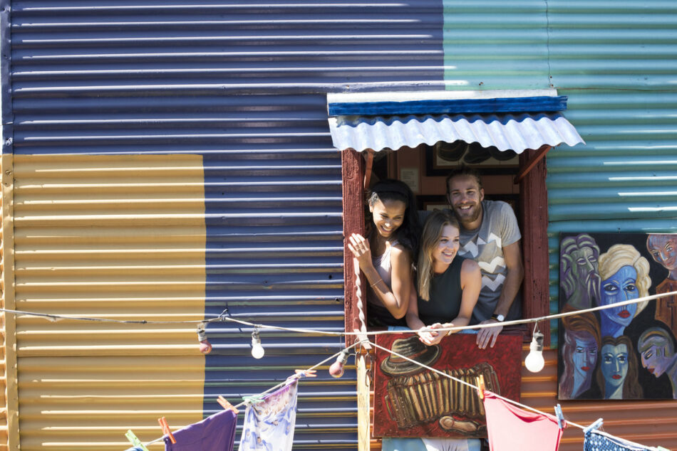 Friends hanging out of a window in buenos aires, brazil