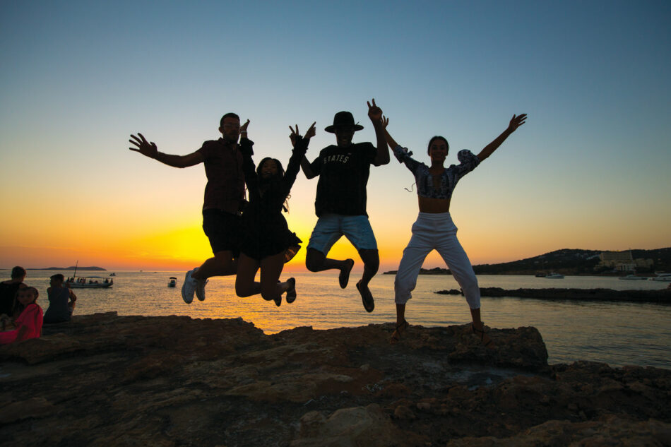 A group of first time travellers jumping in the air.