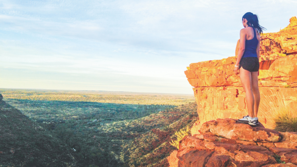 A woman standing on top of a cliff.