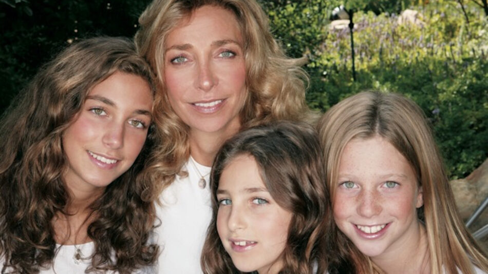 Three young girls posing for a photo with their mother.