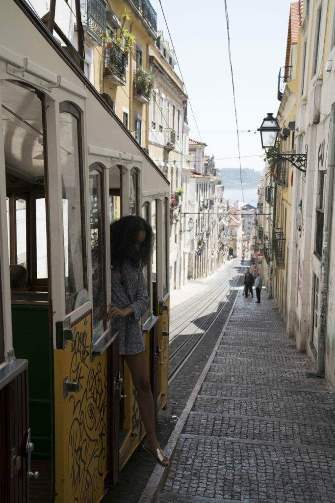 A woman travelling to Portugal standing next to a train.