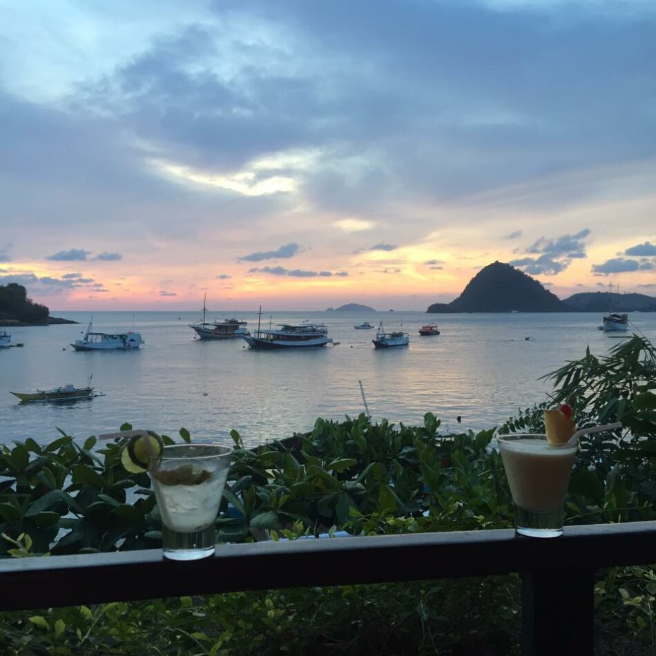 Two glasses of healing cocktails on a balcony overlooking the ocean, offering a cure for a break-up.