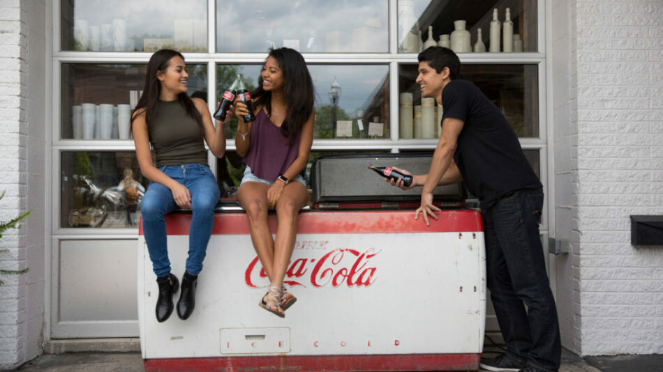 How do I sit on top of a Coca Cola cooler?