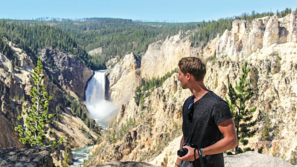 man looking at a waterfall