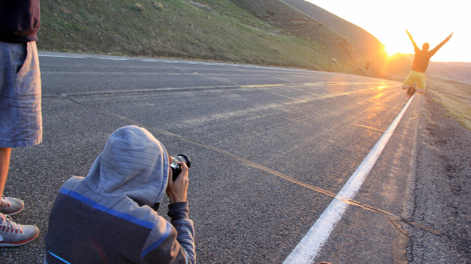 A man with a travel addiction captures an image of a skateboarder.