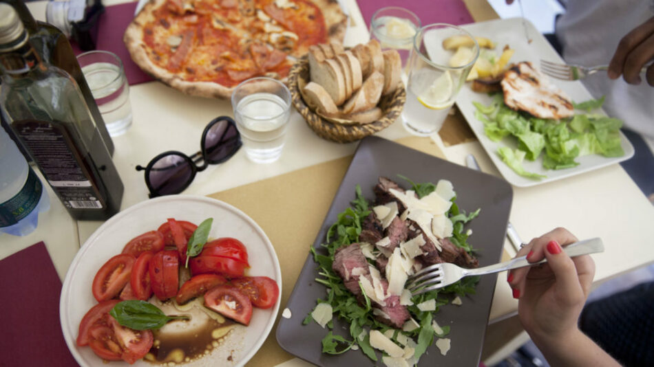 A group of people spending money while eating food at a table.