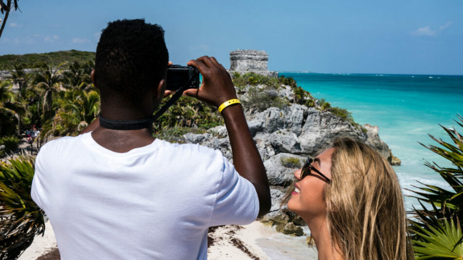 A man and woman capturing a moment of self love at the ocean in Tulum, Mexico.