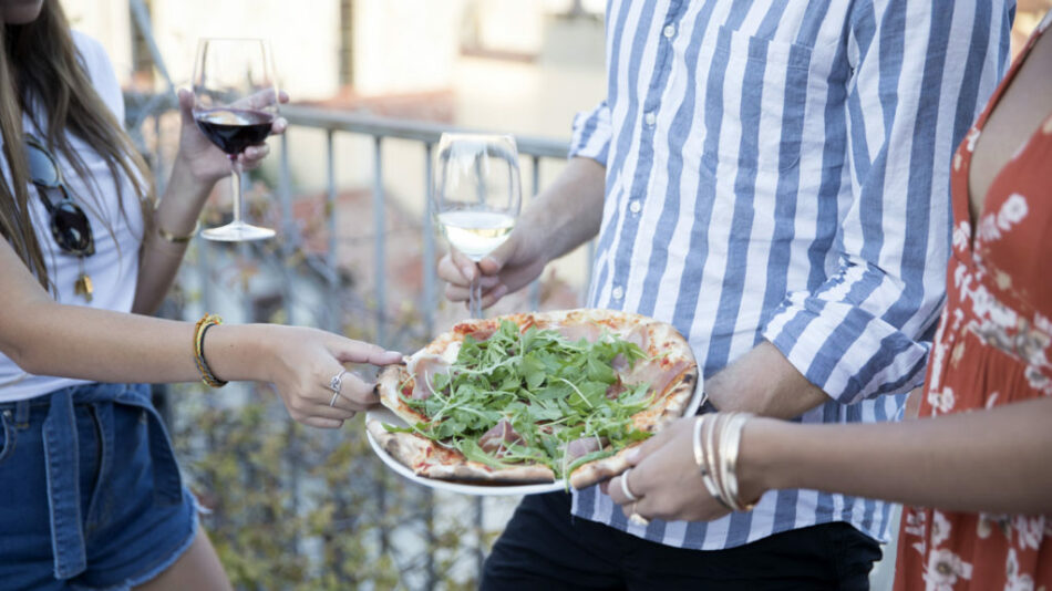 A group of people enjoying pizza at a food festival.