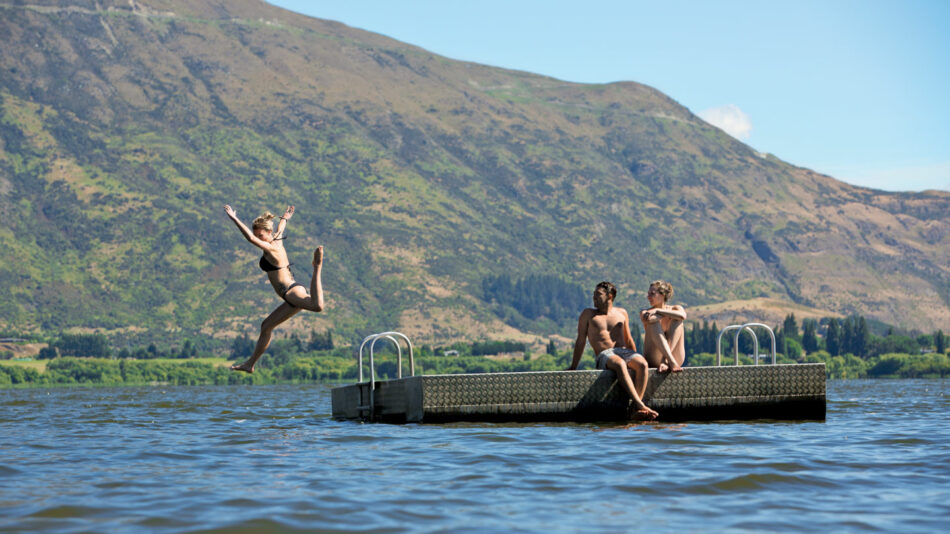 group jumping off jetty in New Zealand