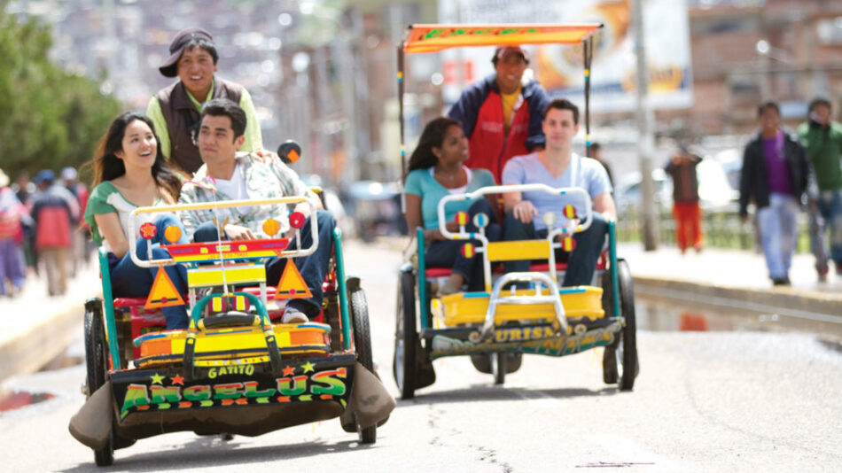 A group of people riding in a Contiki rickshaw in Latin America.