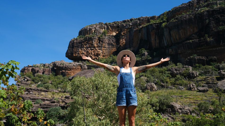 A sarain standing on a rock with her arms outstretched.