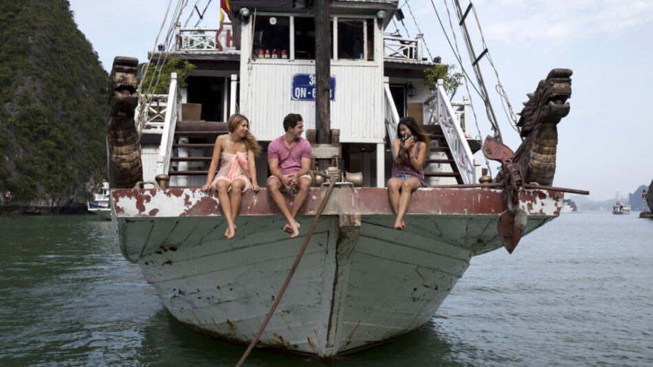 Three travelers on a boat in Vietnam.