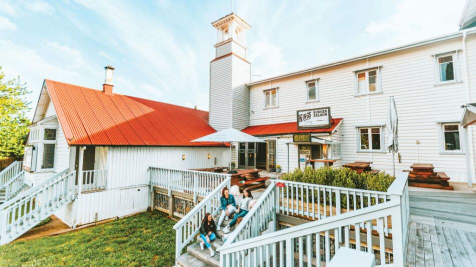 A Contiki Special Stays accommodation with a unique white building and red roof.