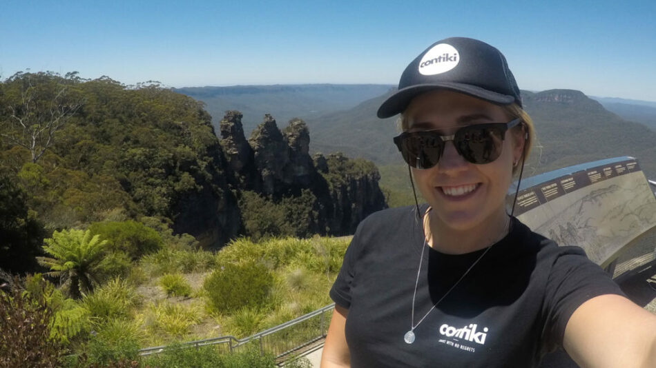 A Contiki trip manager is taking a selfie at the top of a mountain in Australia.