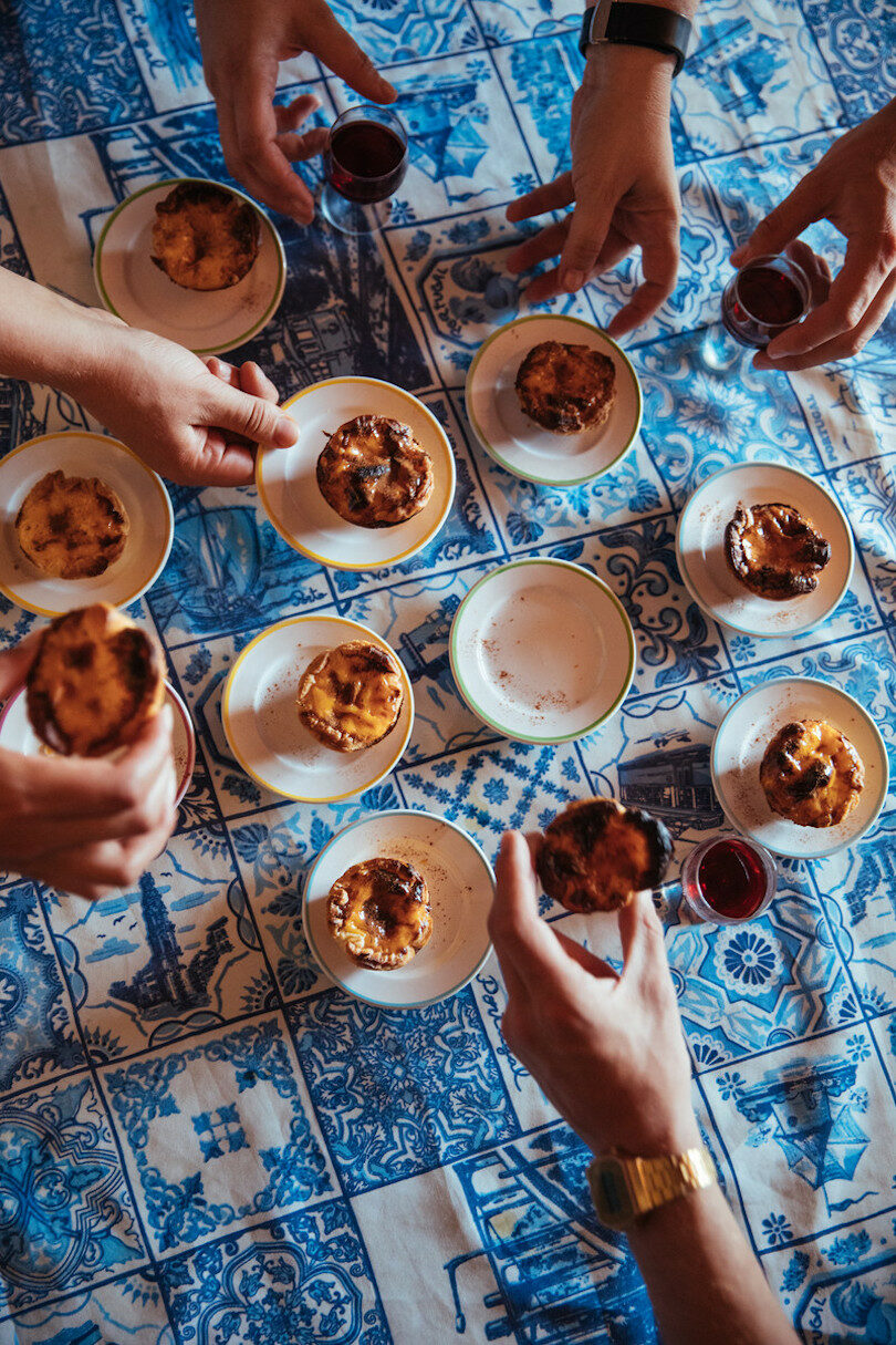 A group of people enjoying European pastries on a table.