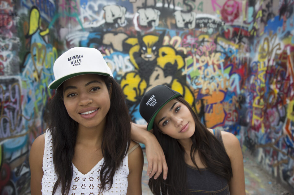 girls in baseball caps smiling to camera