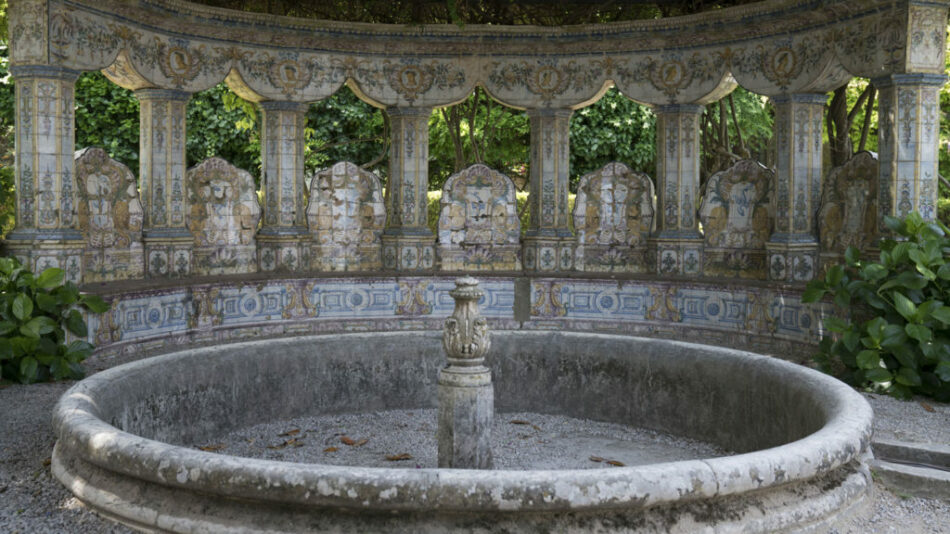 An ornate fountain in a lush garden, perfect for a tranquil stroll while travelling in Portugal.